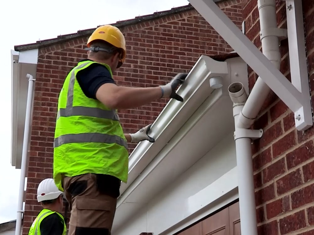 Guttering being fitted along a residential roofline